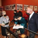 uczestnicy otwarcia wystawy " Zabytkowe sztućce i zastawy stołowe" przy gablocie szklanej w hali Lejniczej